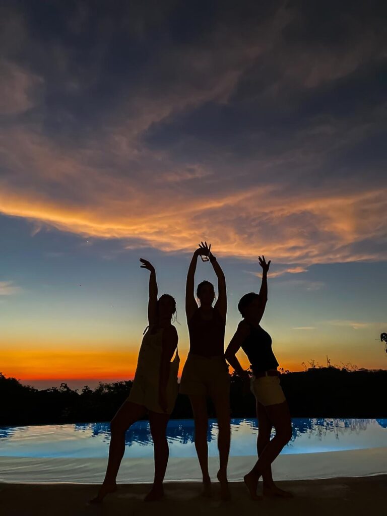 Guests enjoying a colorful sunset by the pool at Pacific Kalokairi in Tamarindo, Costa Rica