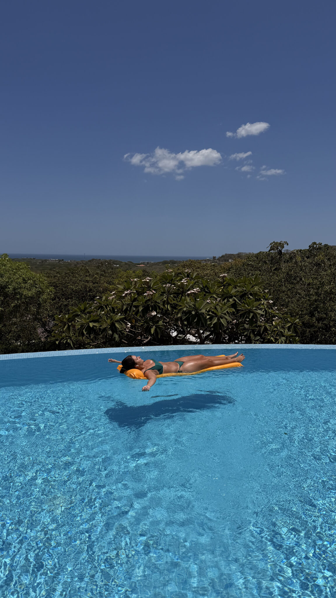 Guest relaxing on a float in the infinity pool at Pacific Kalokairi adults-only hotel in Tamarindo.